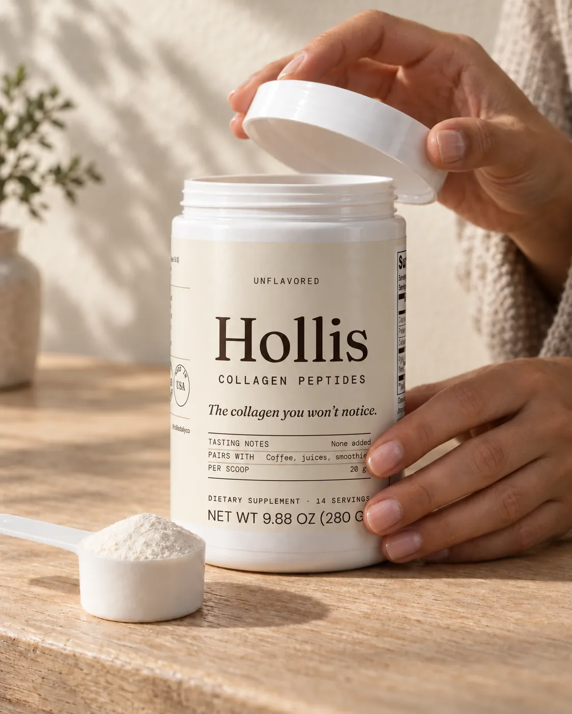 A hand lifting the lid off the Hollis container on a sunlit counter