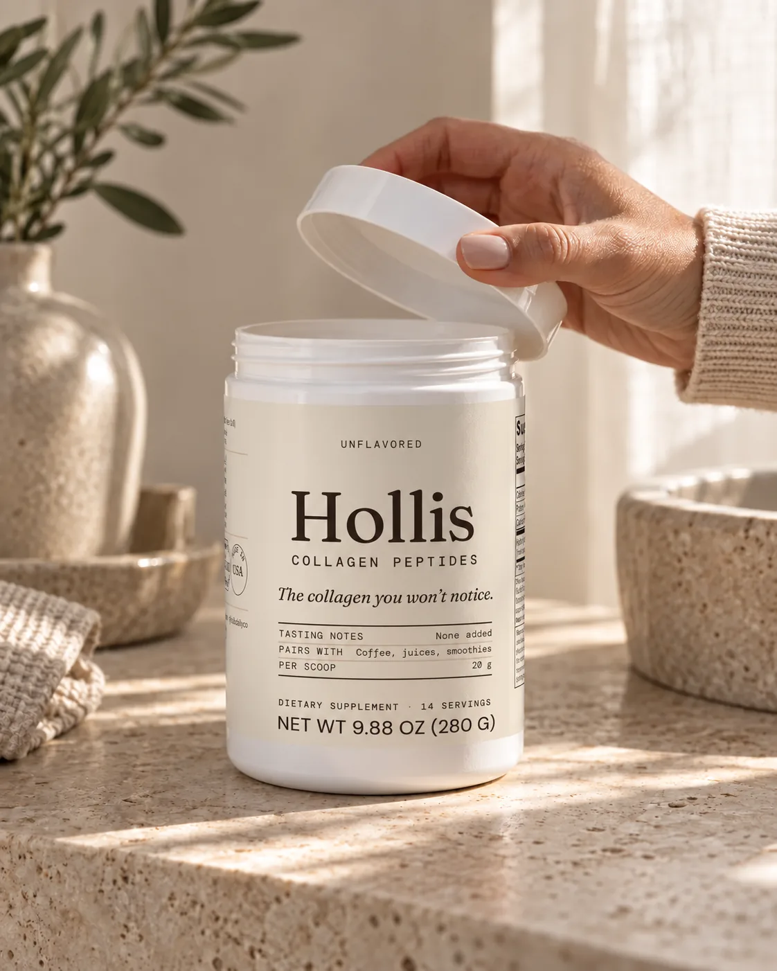 A hand lifting the lid off the Hollis container