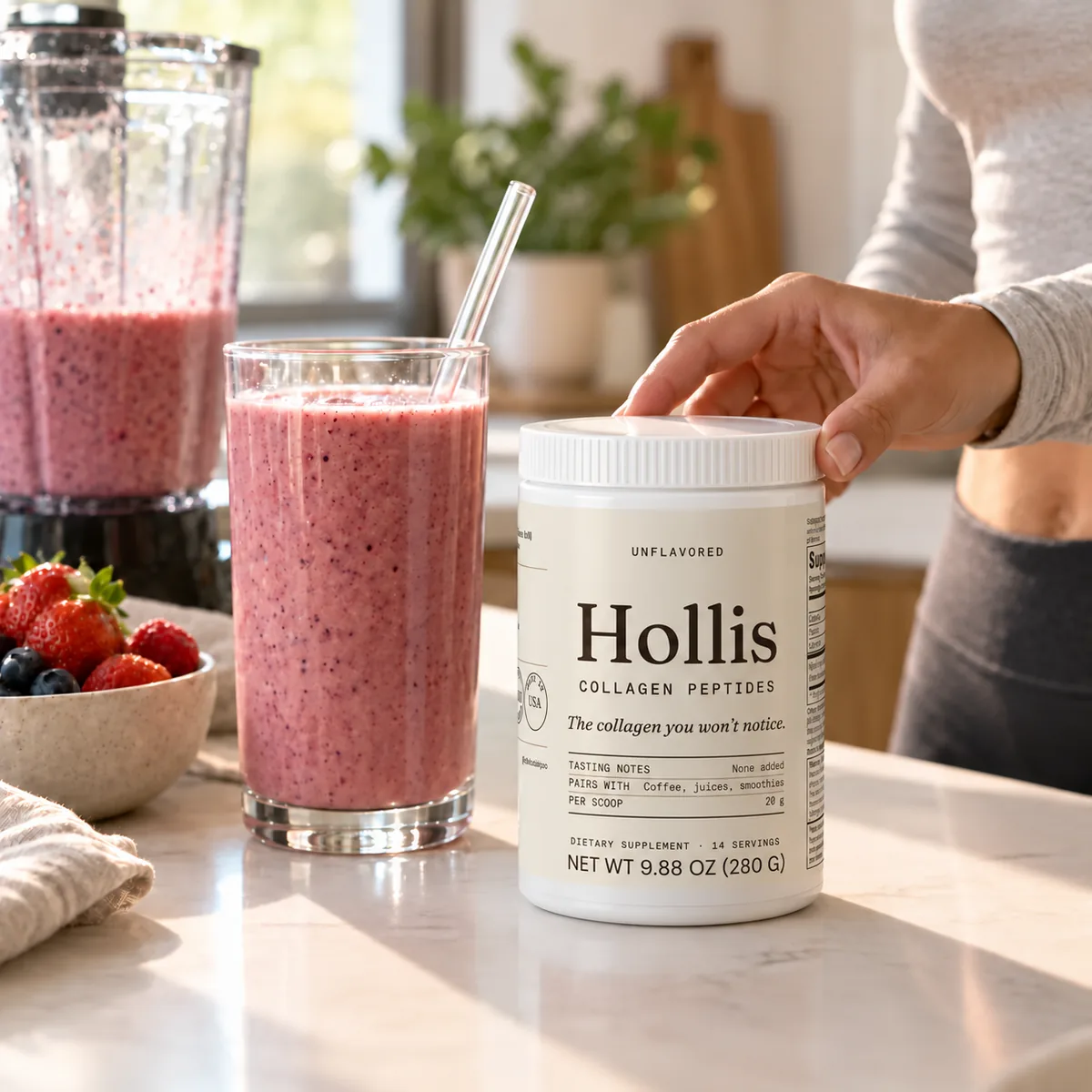 A hand reaching for the Hollis container next to a smoothie